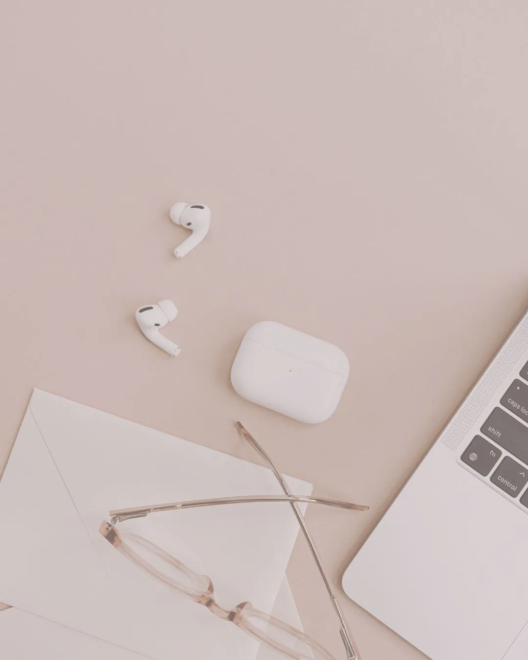 Λάπτοπ με γυαλιά και ασύρματα ακουστικά σε μπεζ γραφείο – Rodi Stoeri Translation Services